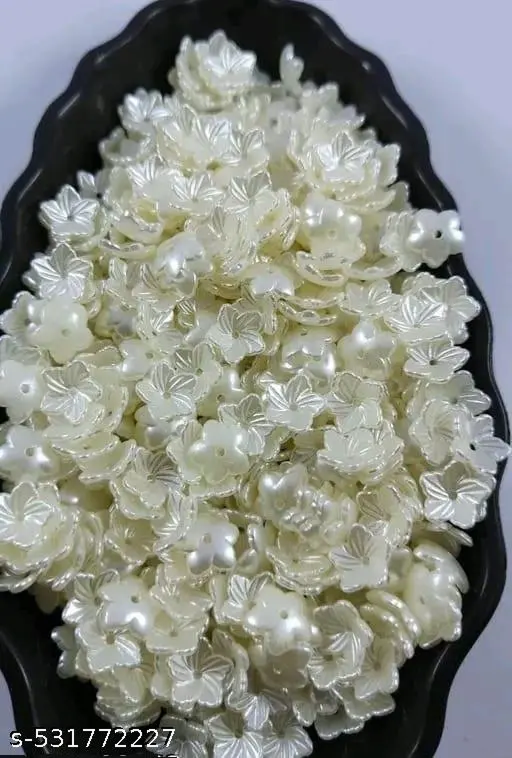 White floral-shaped candies in a black dish on a white background